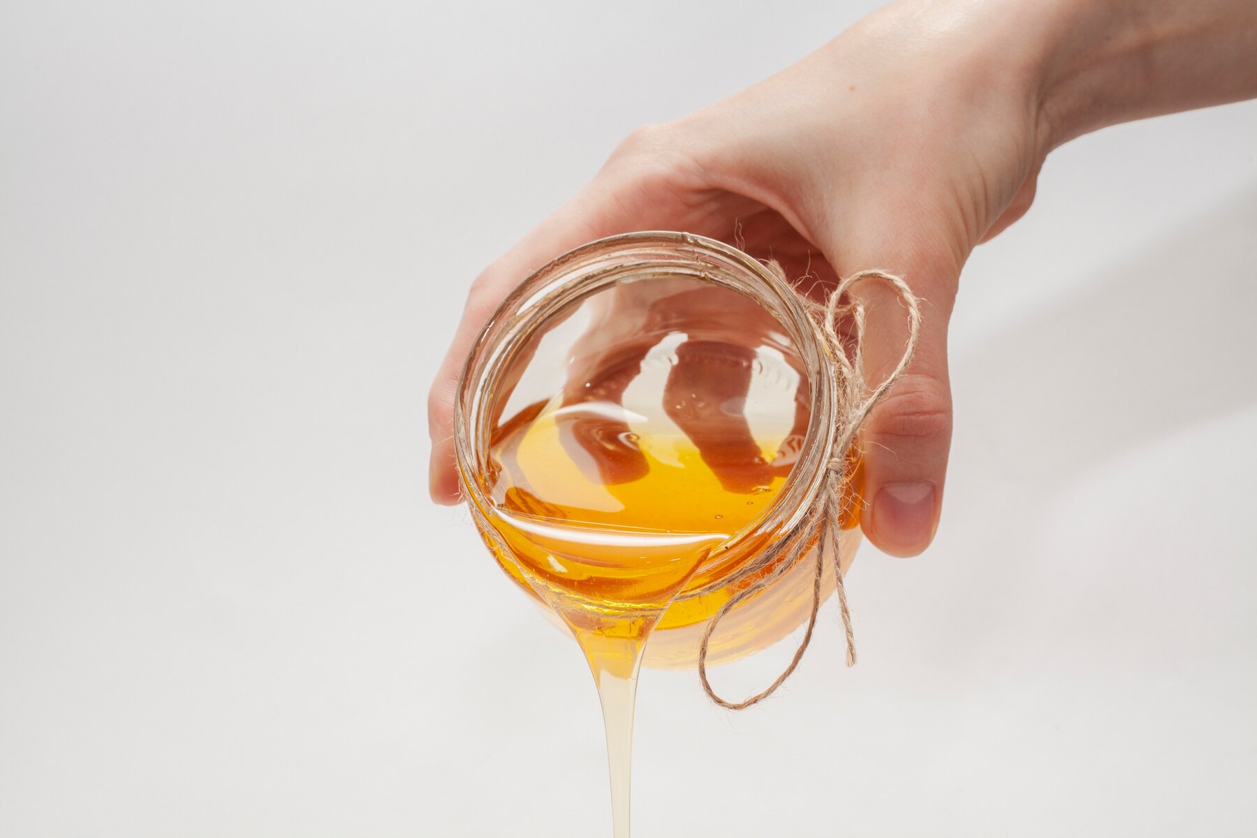 hand-pouring-honey-from-a-jar_23-2148371973.jpg