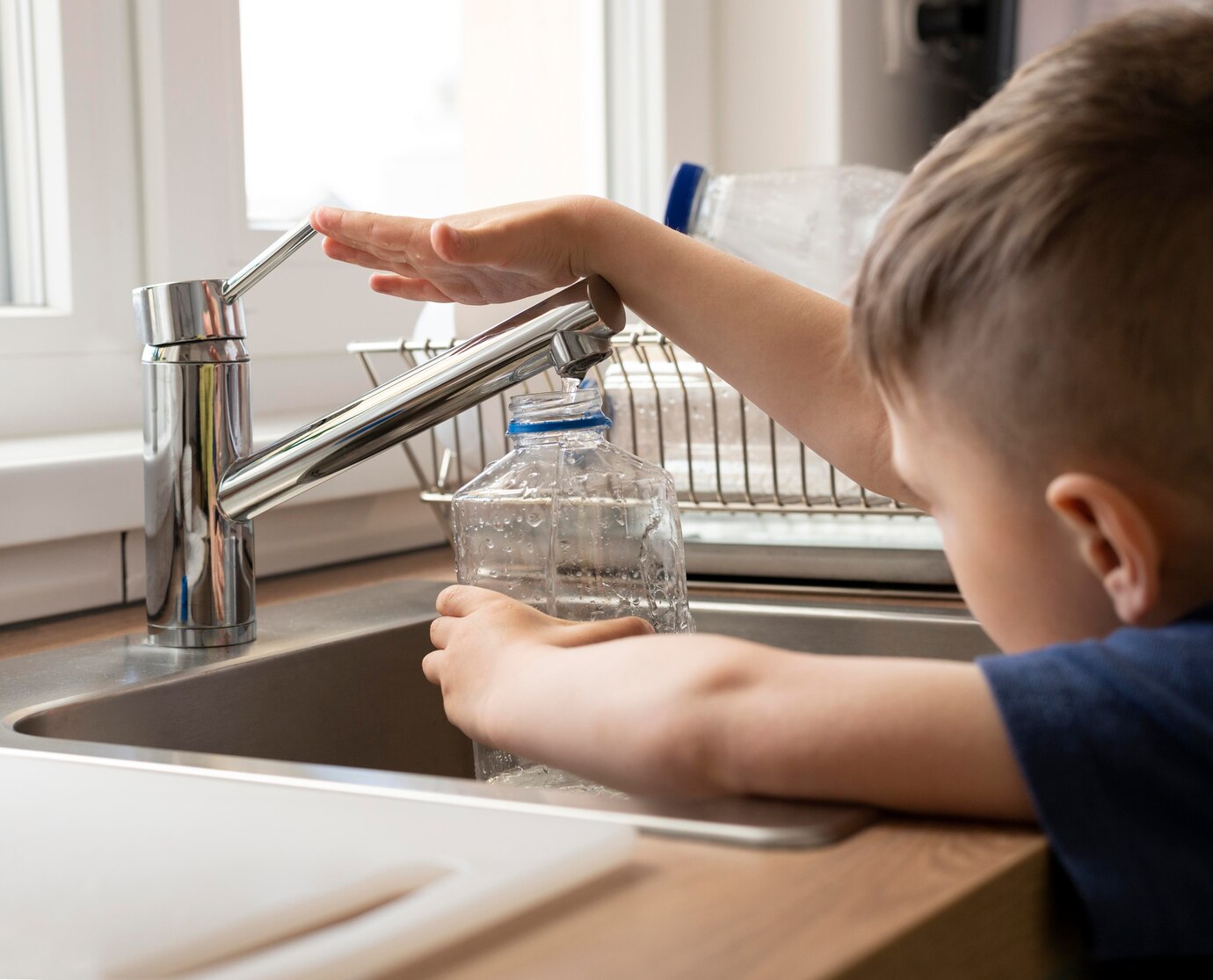 close-up-kid-filling-bottle-with-water_23-2148972906.jpg