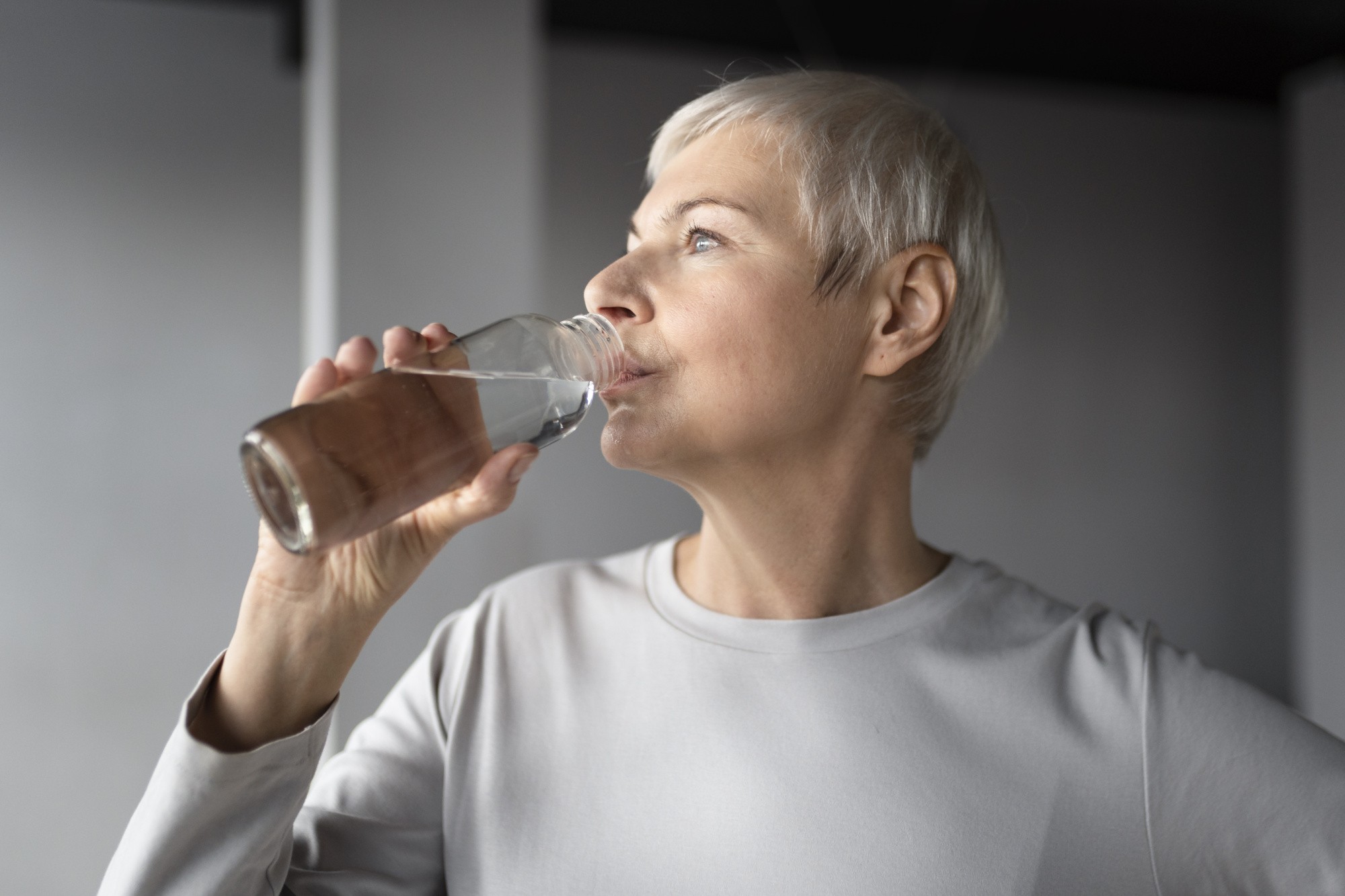 elderly-woman-drinking-water-after-workout-gym.jpg