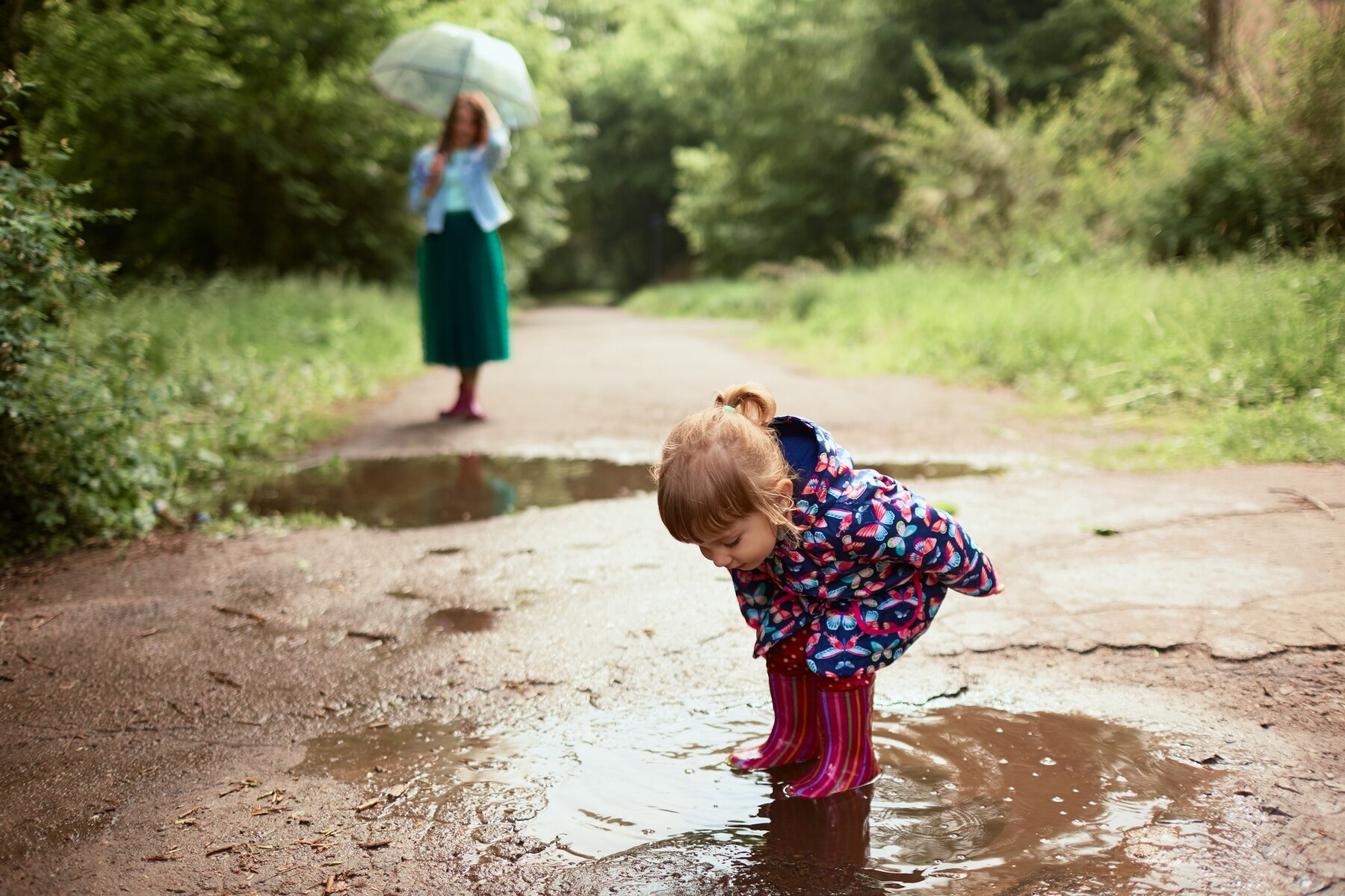 young-mom-little-daughter-have-fun-walking-gumboots-pools-park_8353-7613.jpg