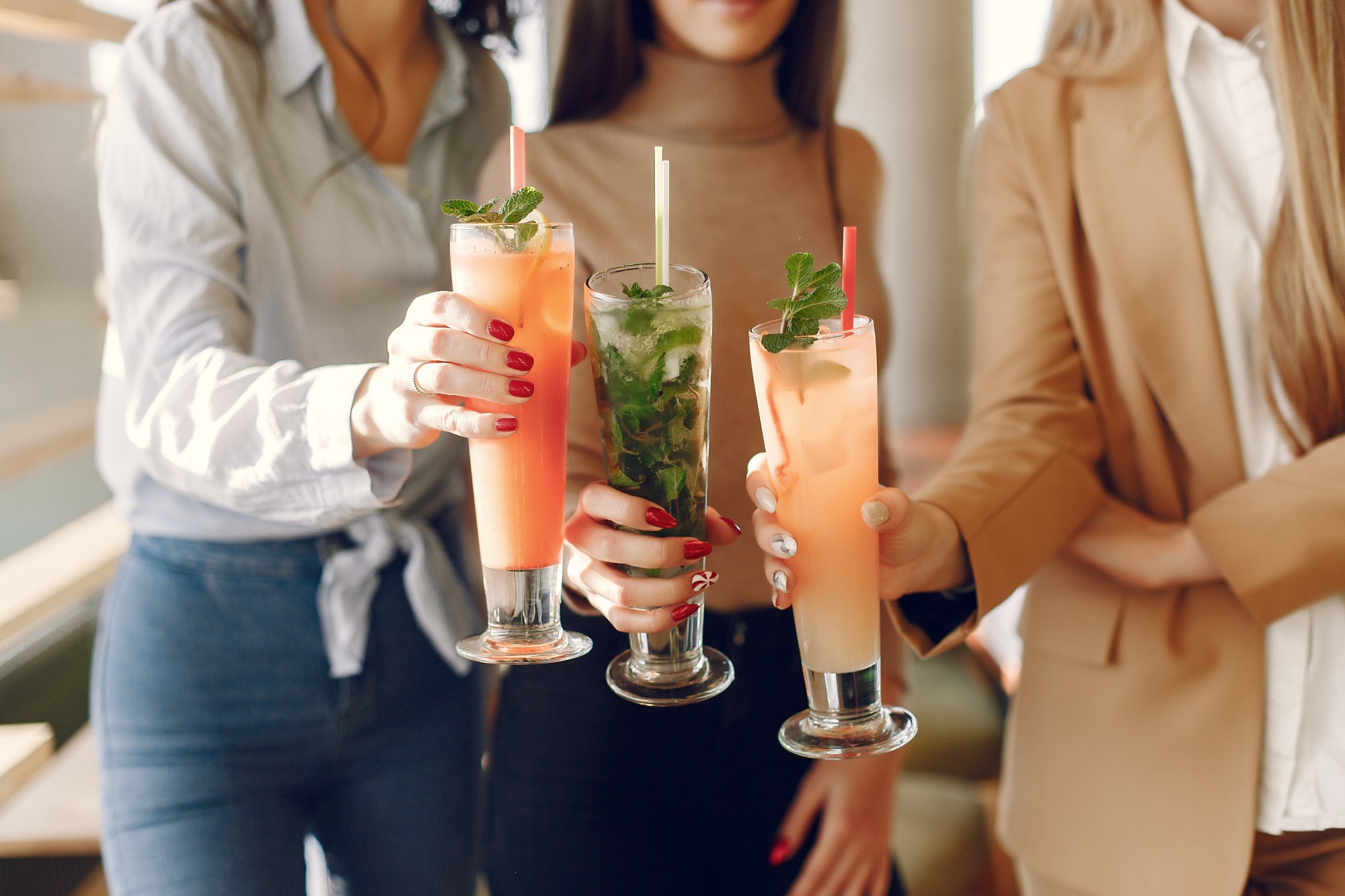 elegant-women-standing-cafe-drinking-cocktails.jpg