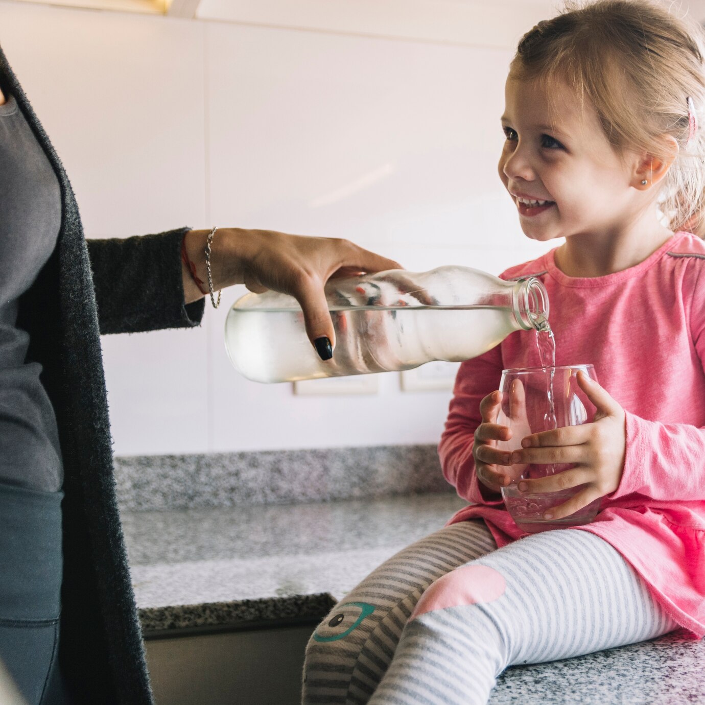 woman-s-hand-pouring-water-in-glass-for-her-happy-daughter_23-2147878212.jpg